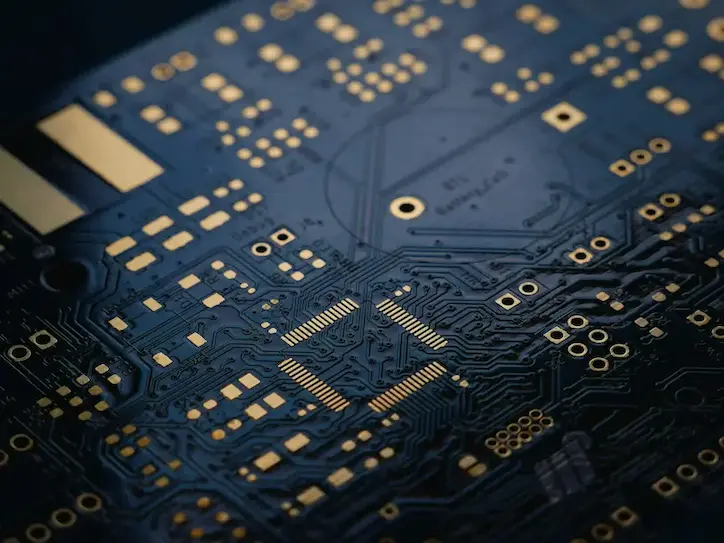 Close-up of blue PCB circuit board with golden contacts and integrated circuits